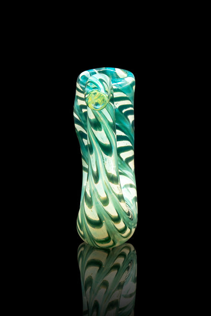 Green and white swirled glass pipe with a reflective surface, isolated on black.
