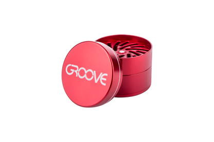 A close-up, angled view of the Aerospaced Groove 4-Piece Aluminum Grinders, showcasing its metallic finish and multi-part design.