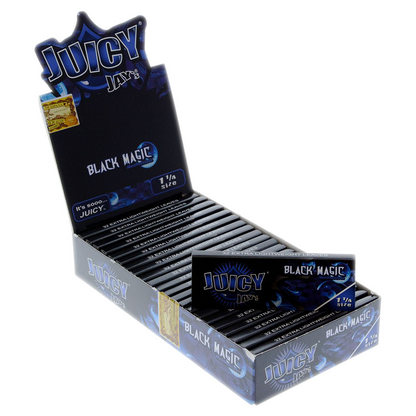 A close-up of Juicy Jay's 1 1/4 Black Magic Rolling Papers packaging, with the black pack angled slightly toward the viewer.
