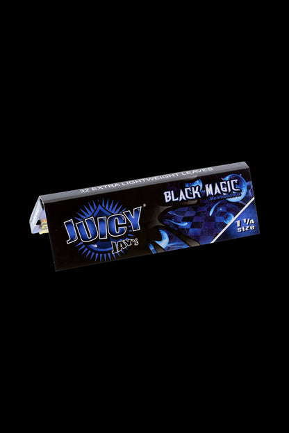 A close-up of the black packaging for Juicy Jay's 1 1/4 Black Magic Rolling Papers, displaying bold lettering and branding details.