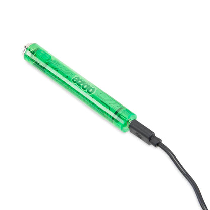 Glowing green cannabis oil vape pen with USB charging cable.