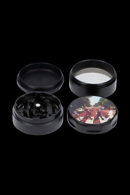 A top-down view of the Rock Legends Grinder - Fab4 Abbey Road, featuring a circular, black grinder with a textured surface.