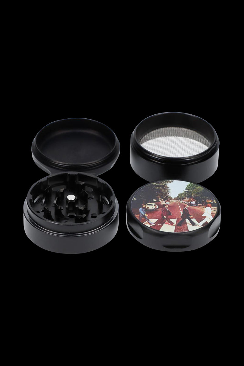 A top-down view of the Rock Legends Grinder - Fab4 Abbey Road, featuring a circular, black grinder with a textured surface.