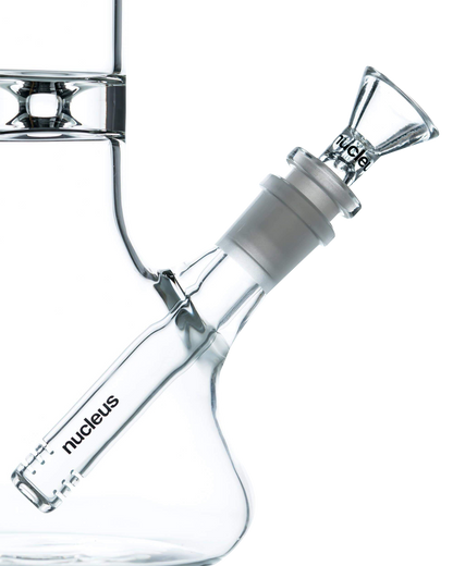 A three-quarter view of the Nucleus 12" Beaker Bong with Donut Style Ice Catcher, showcasing its clear glass construction and wide base.