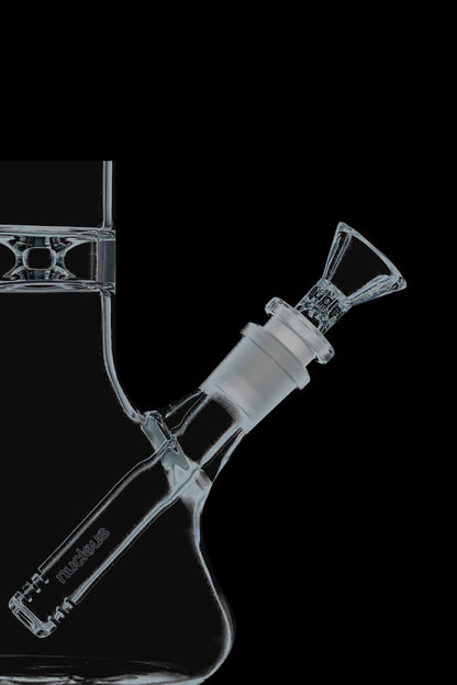 A straight-on view of the Nucleus 12" Beaker Bong with Donut Style Ice Catcher, showcasing its clear glass construction and wide base.