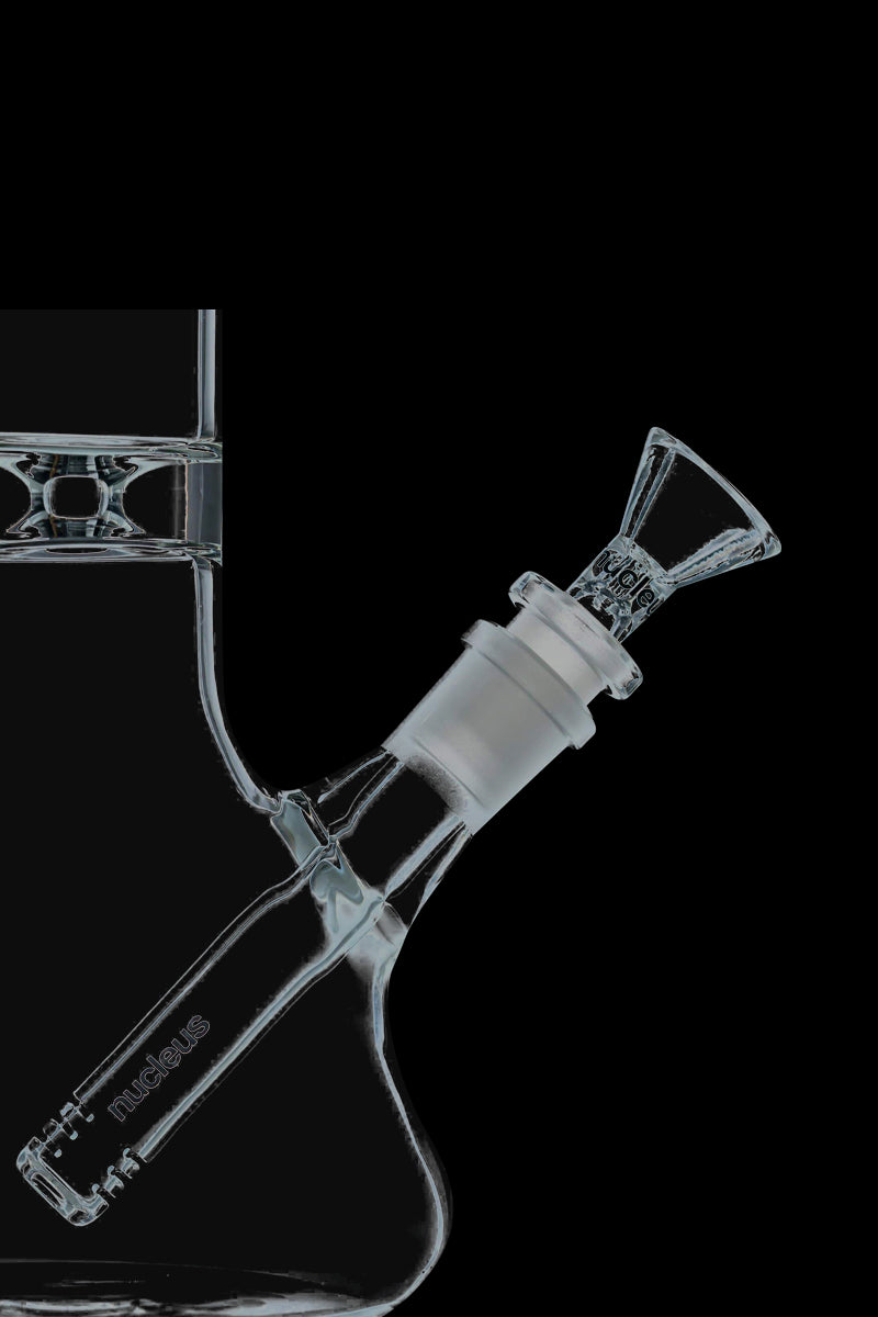 A straight-on view of the Nucleus 12" Beaker Bong with Donut Style Ice Catcher, showcasing its clear glass construction and wide base.