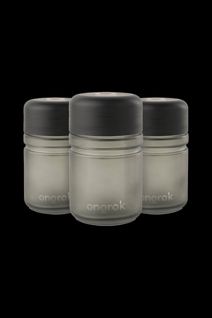 Three Onrok cannabis oil vape cartridges with black caps and frosted glass bodies against a black background.