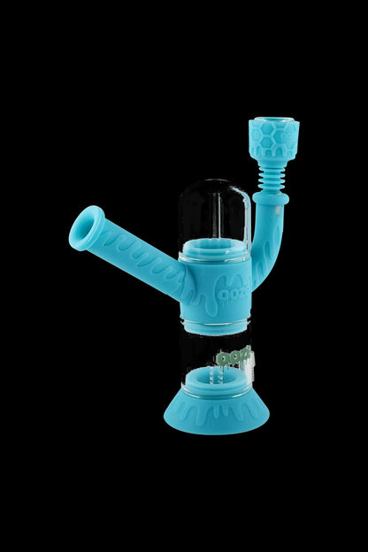 A studio shot of the Ooze "Cranium" Silicone 4-in-1 Glass Water Pipe, displaying its transparent glass construction and unique skull-shaped design.