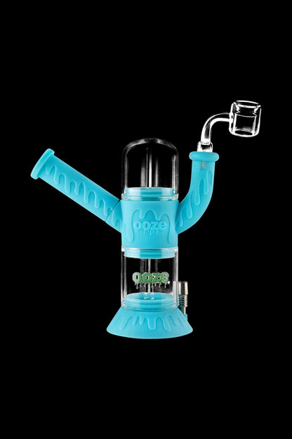 A studio shot of the Ooze "Cranium" Silicone 4-in-1 Glass Water Pipe, showcasing its clear glass construction and unique, curved design.