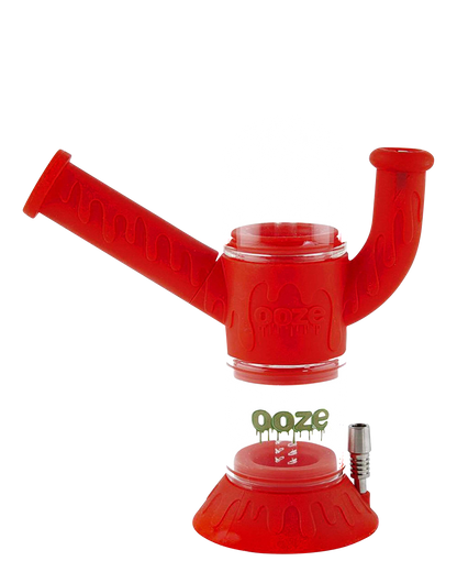 A studio shot of the Ooze "Cranium" Silicone 4-in-1 Glass Water Pipe, displaying its colorful, patterned silicone wrap around a clear glass tube.