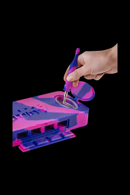 A hand holds the Ooze Slugger Dabbin Dugout, showcasing its open lid and interior details in a close-up shot.