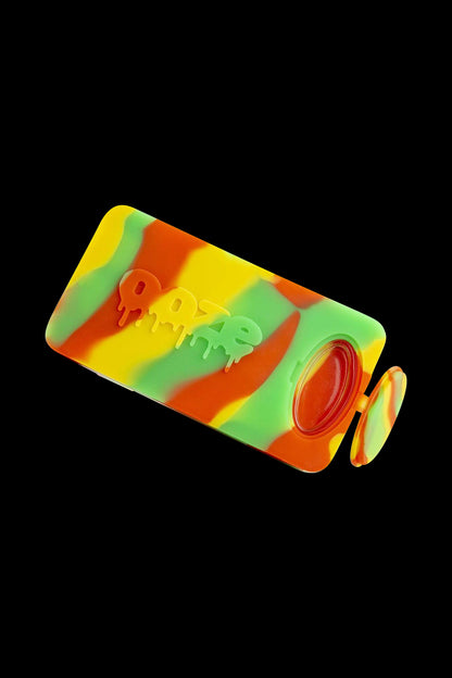 A side view of the Ooze Slugger Dabbin Dugout, featuring a curved, colorful design and a compact, handheld form.