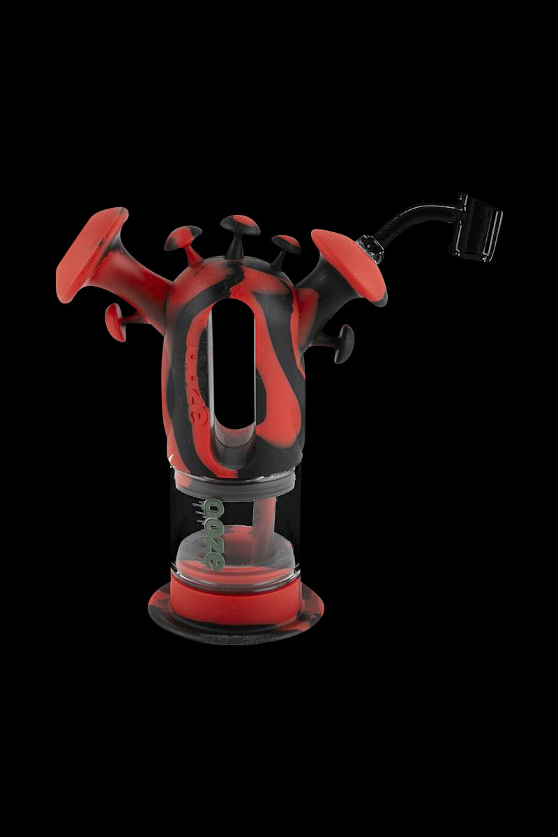 A close-up of the Ooze "Trip" Silicone Bubbler, showcasing its vibrant red, sculpted design against a black background.