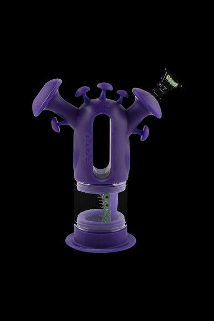 A studio shot of the Ooze "Trip" Silicone Bubbler, showcasing its purple, rounded shape and compact design against a black background.