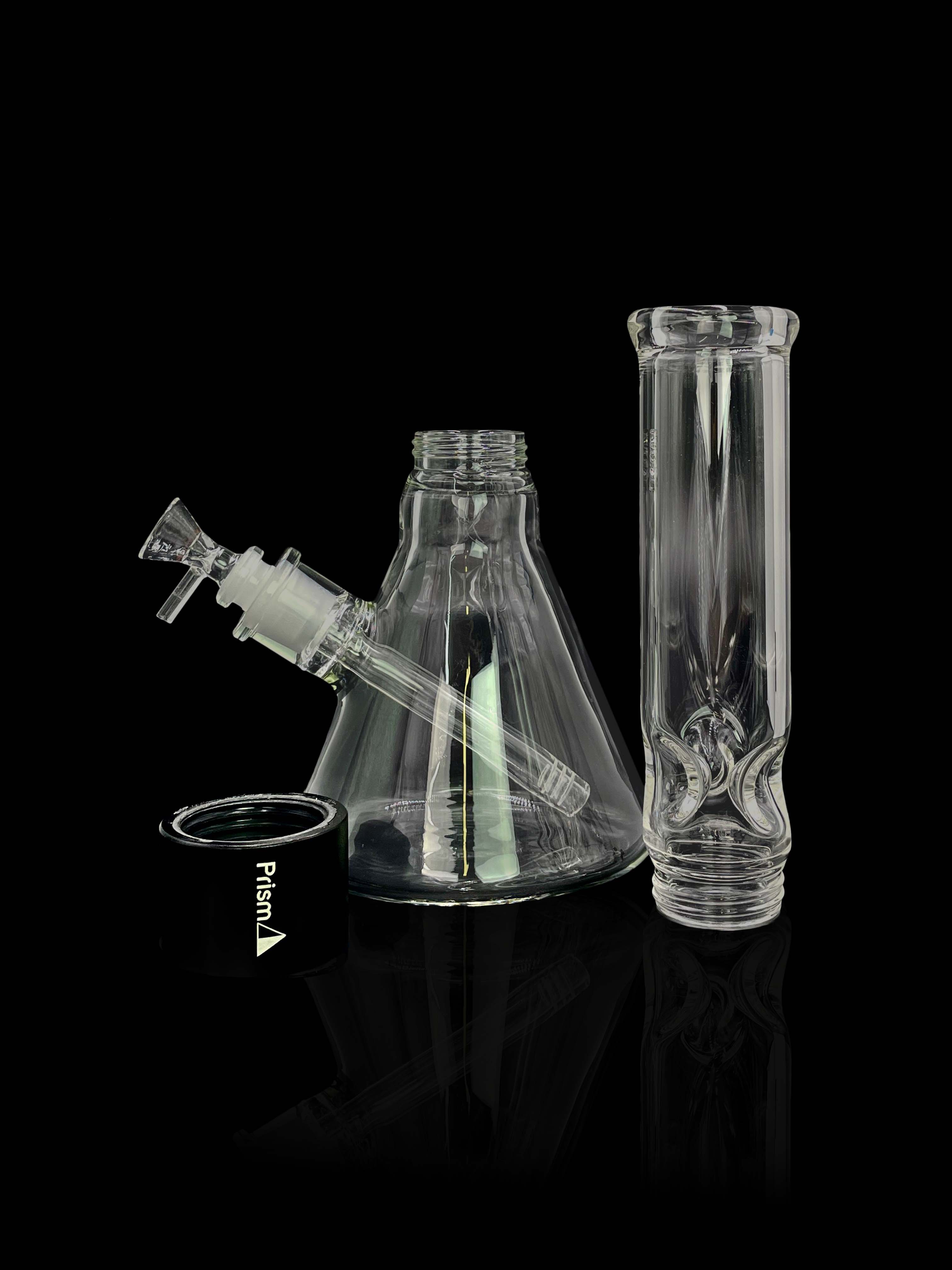 A studio shot features the Prism Water Pipes Starter Kit, highlighting the clear glass pipe angled against a dark backdrop.