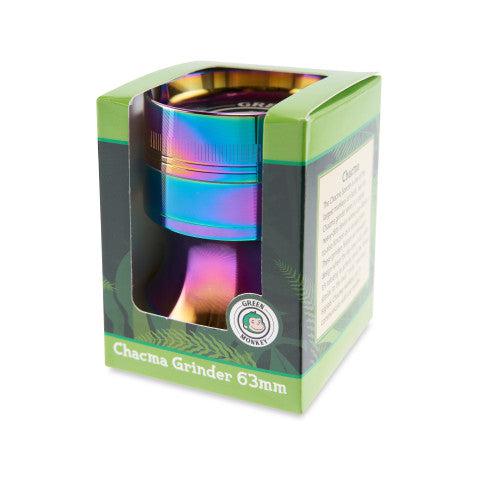 Three-quarter view of a rainbow-finish Green Monkey Chacma Grinder with Ashtray in its green retail box, lit from the top against a white background