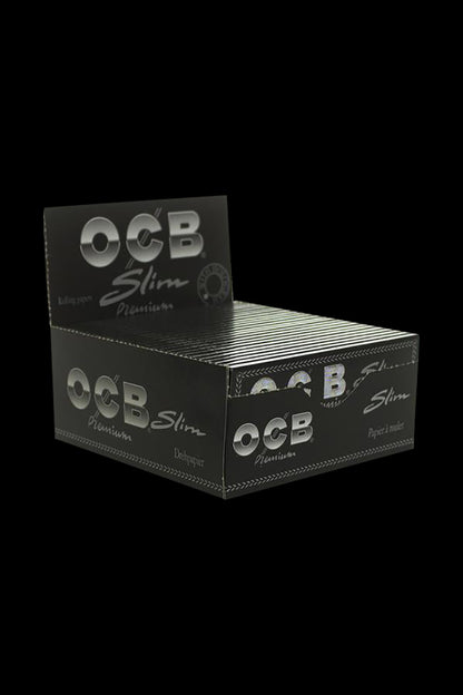 A stack of OCB Premium Single Wide Rolling Papers against a plain black background, viewed from a slightly angled, close-up perspective.