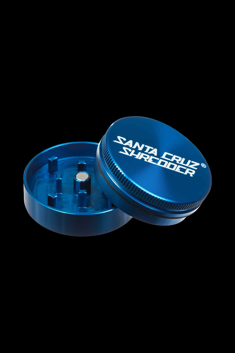 A close-up, angled view of the Santa Cruz Shredder Small 2-Piece Grinder, showcasing its metallic, two-part construction.