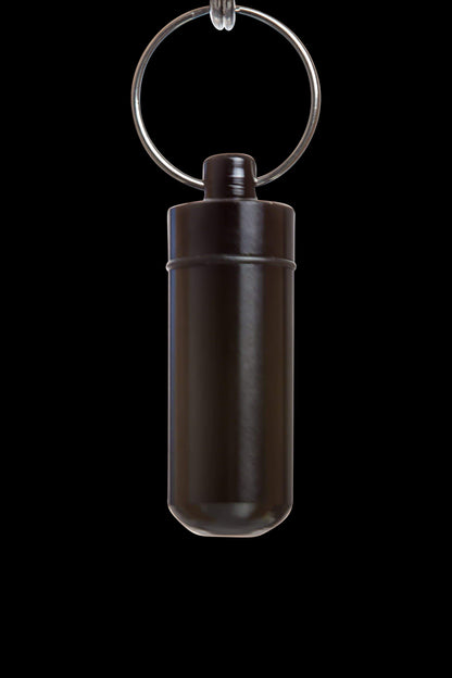 Front view of the Discrete Key Chain Stash Jar, a sleek, silver container suspended by a circular key chain against a dark backdrop.