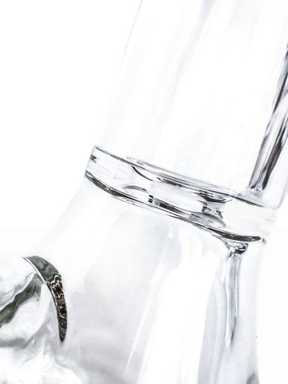 A close-up, angled view of the Tank Glass "MAX" Beaker Bong, showcasing its clear glass construction and simple beaker shape.