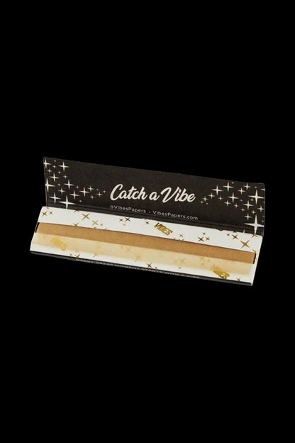 A package of VIBES King Size Slim Ultra Thin Rolling Papers is shown in a close-up, top-down view on a dark surface.